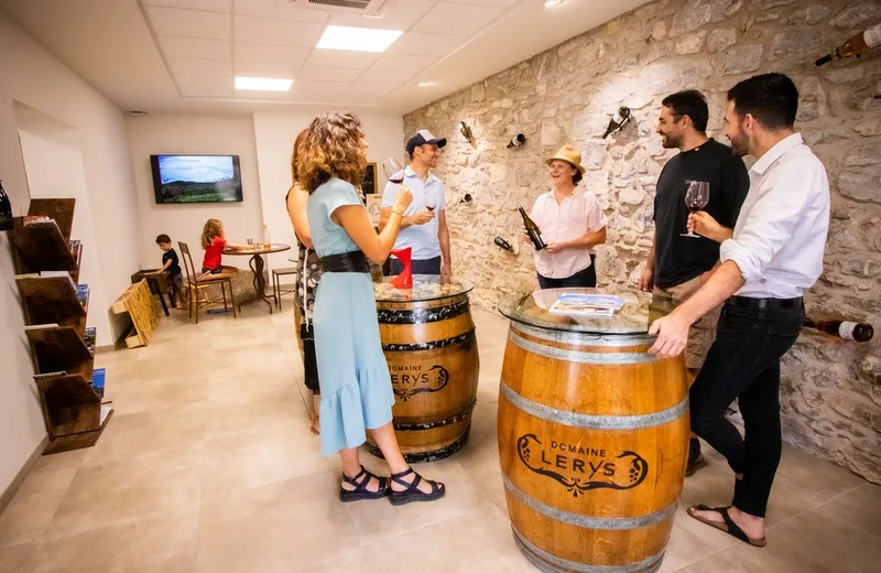 Dégustation de vins en groupe autour d'un fût au Domaine Lerys